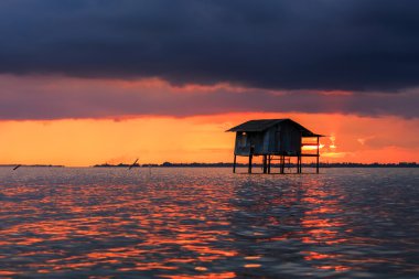 Gün batımı ile fırtına öncesi deniz üzerinde kara bulutlar
