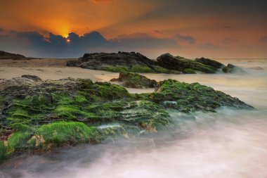 Sahilde rock ile üzerinden gündoğumu görünüm