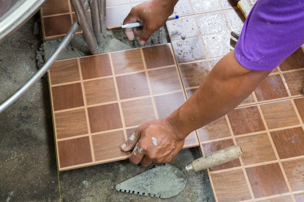 stock image floor tiling by manual worker