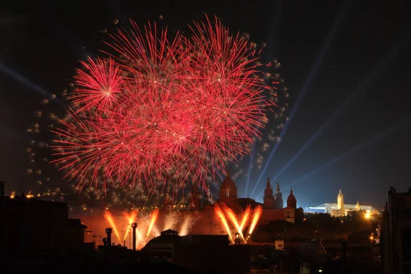 fireworks in the sky with buildings in the background