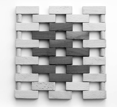 Küçük ahşap tuğlalardan yapılmış bir duvar. Beyaz arka planda tuğla duvarını andıran siyah ve beyaz tahta bloklar. Doku. Arkaplan.