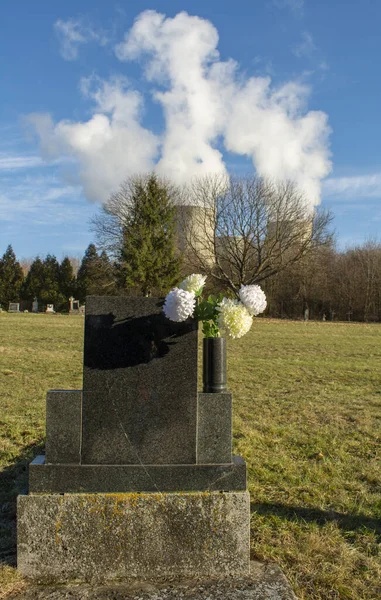 墓碑后视镜 坟场上有人造花卉 后台核电厂冷却塔的设计 — 图库照片