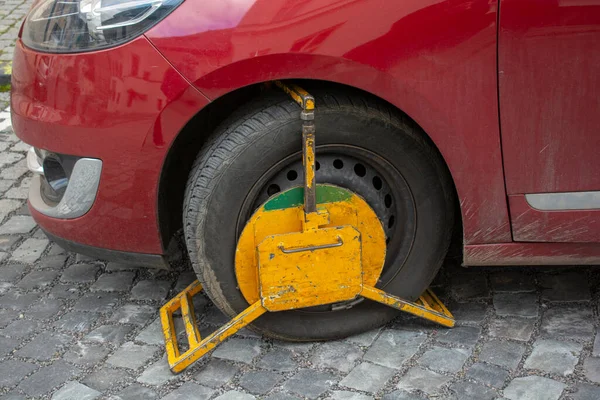 前轮因擅自或非法停车而被轮锁堵塞的前轮车轮钳也被称为车轮靴或停车靴 — 图库照片