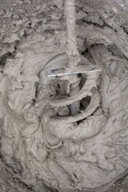 Alçı çözeltisini elektrikli matkapla karıştırıyorum. Yapıştırıcı karışımı. Ev yenilenmesi.