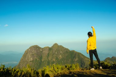 adam başarı bir dağın tepesinde kutluyor