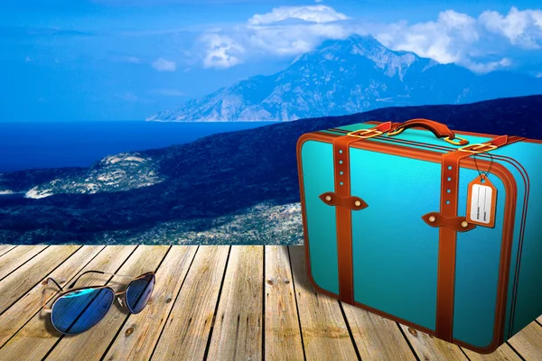 Деревянный пирс с солнцезащитными очками и чемоданом, рядом с тропическим видом на пляж в Халкидики — стоковое фото