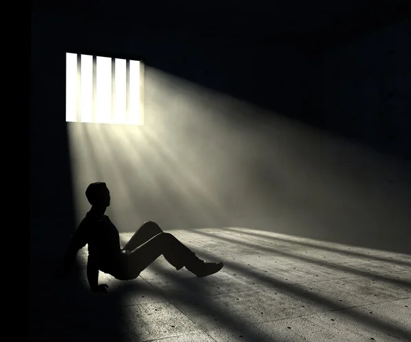 В'язень у темній кімнаті зі світлими променями — стокове фото