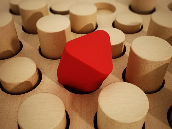 Красная призма деревянный блок выделяется среди деревянных цилиндров. 3D иллюстрация — стоковое фото