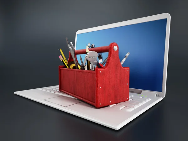 Caixa de ferramentas vermelha em pé no computador portátil — Fotografia de Stock