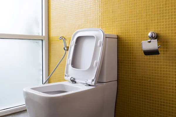 Bianco toilette a filo e parete gialla decorazione a mosaico — Foto Stock