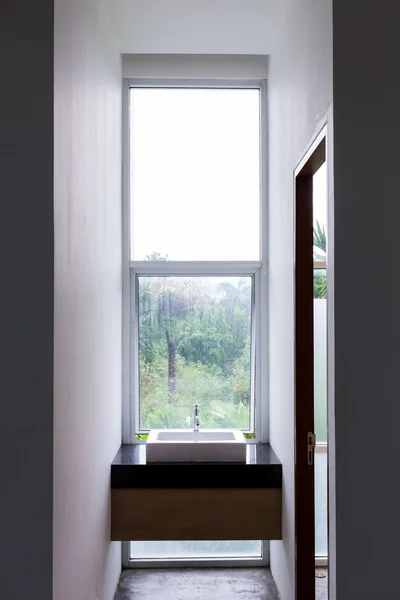 Lavabo en el cuarto de baño con espejo transparente ventana vista naturaleza — Foto de Stock