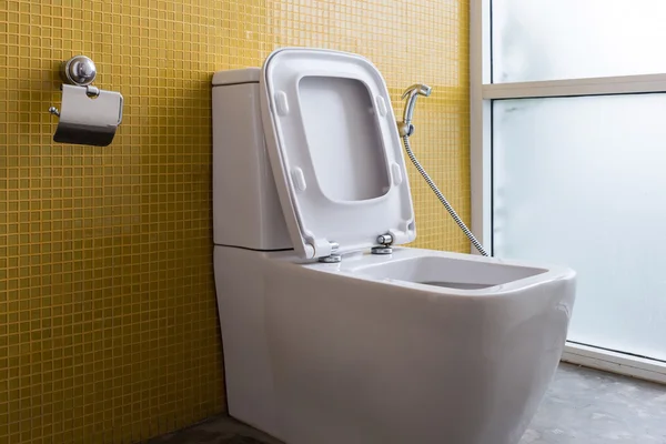 White flush toilet and yellow wall mosaic decoration — Stock Photo, Image