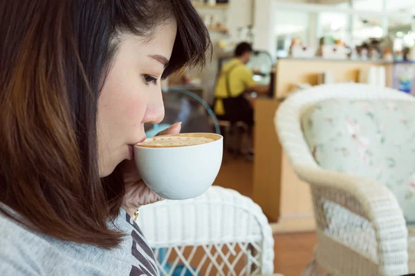 Donna che beve caffè caldo o tè nel caffè, modello asia — Foto Stock