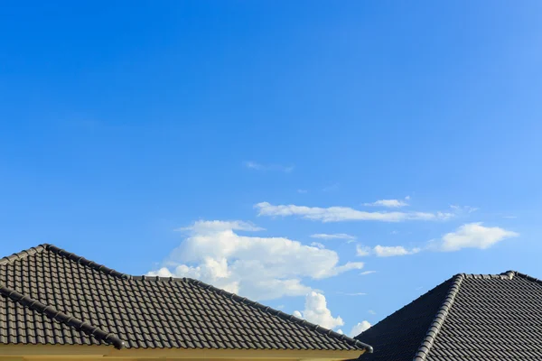 黑瓦屋顶上湛蓝的天空背景下的新房子 — 图库照片