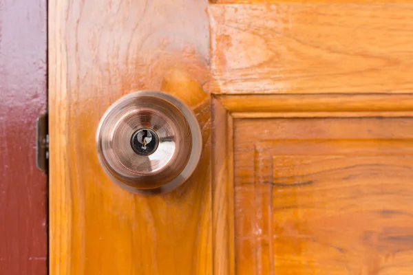 Дверная ручка и замочная скважина на деревянной двери — стоковое фото