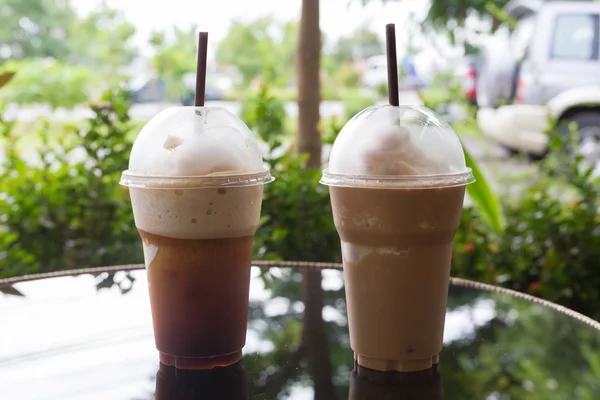 Kaltes Eiskaffeegetränk auf Glastisch gestellt — Stockfoto