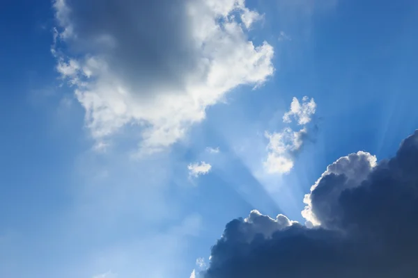 Sunbeam van zonlicht door wolken op de heldere blauwe hemel — Stockfoto