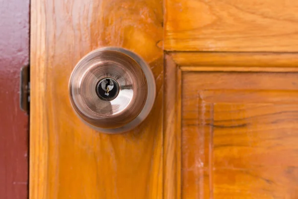 Дверная ручка и замочная скважина на деревянной двери — стоковое фото