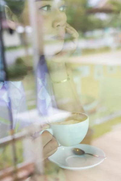 Frau trinkt heißen Kaffee im Café — Stockfoto