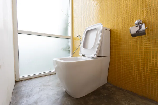 Bílý splachovací záchod a žluté zdi mozaikové výzdoby — Stock fotografie