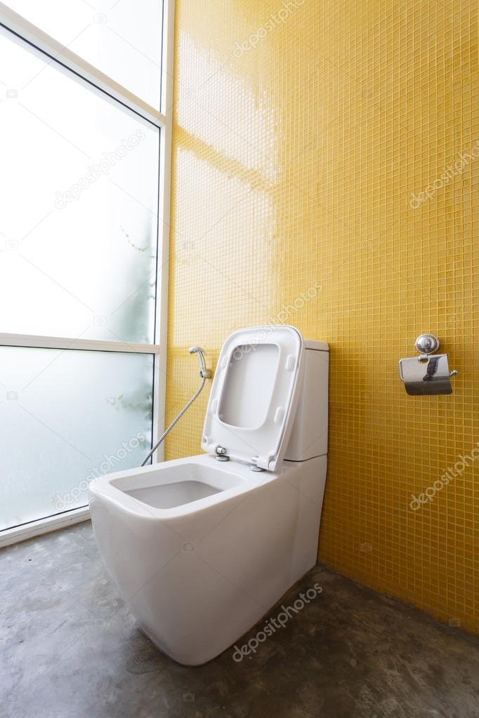 white flush toilet and yellow wall mosaic decoration