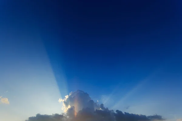 Light of sunbeams through clouds, light rays on dramatic sunset — Stock Photo, Image