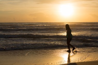 Sahilde, güneş sabah yaz denize yürüyen kadın