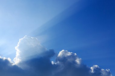 Güneş bulutların üstünde açık mavi gökyüzü ile güneş ışığı