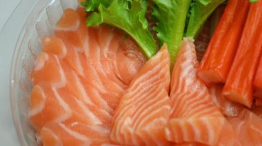 Salata somon balığı ve yengeç çubuğu tabakta, 4k döngü sahnesi.