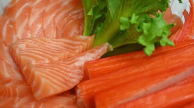 Salata somonlu saşimi ve yengeç çubuğu tabakta, 4k dönüşümlü sahne