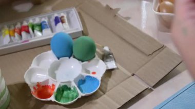 İnsanlar mavi paskalya yumurtası el işi boyama fırçası kullanıyorlar.