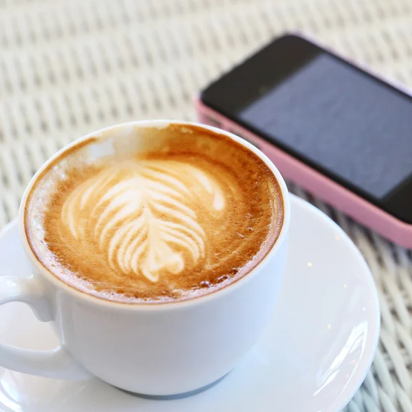 コーヒーとカフェの白いテーブルの携帯電話 — ストック写真