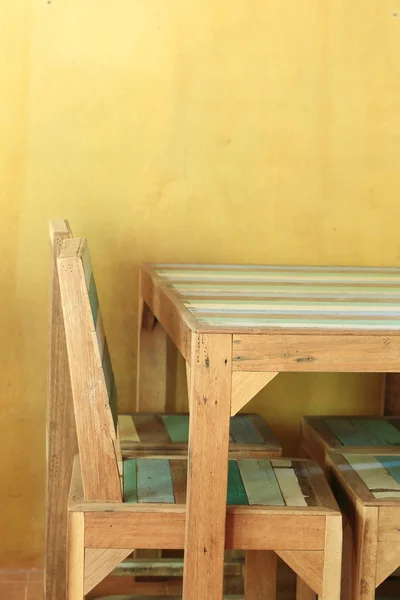 Table wood in yellow room with mortar wall — Stock Photo, Image