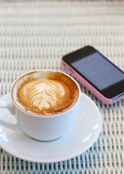 Café e telefone celular na mesa branca no café — Fotografia de Stock