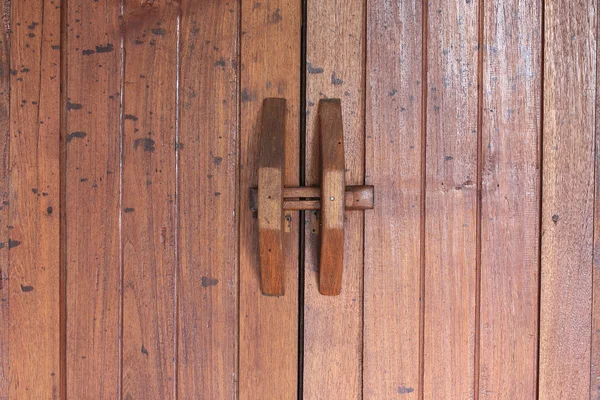 在褐色的木门上的门把手 — 图库照片
