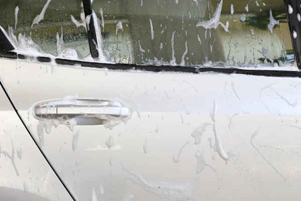 Car wash with water and foam cleaning — Stock Photo, Image
