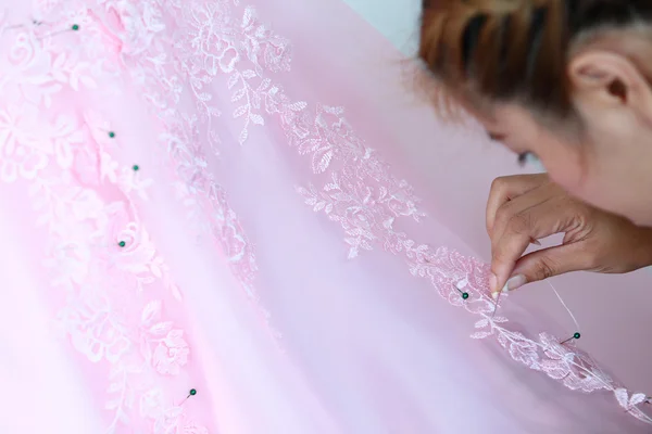 Mulher bordando vestido de noiva rosa — Fotografia de Stock