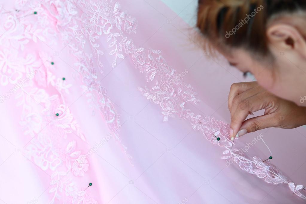 woman embroidering pink wedding dress