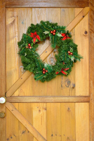 Christmas Krans med dekorationer på trä dörr — Stockfoto