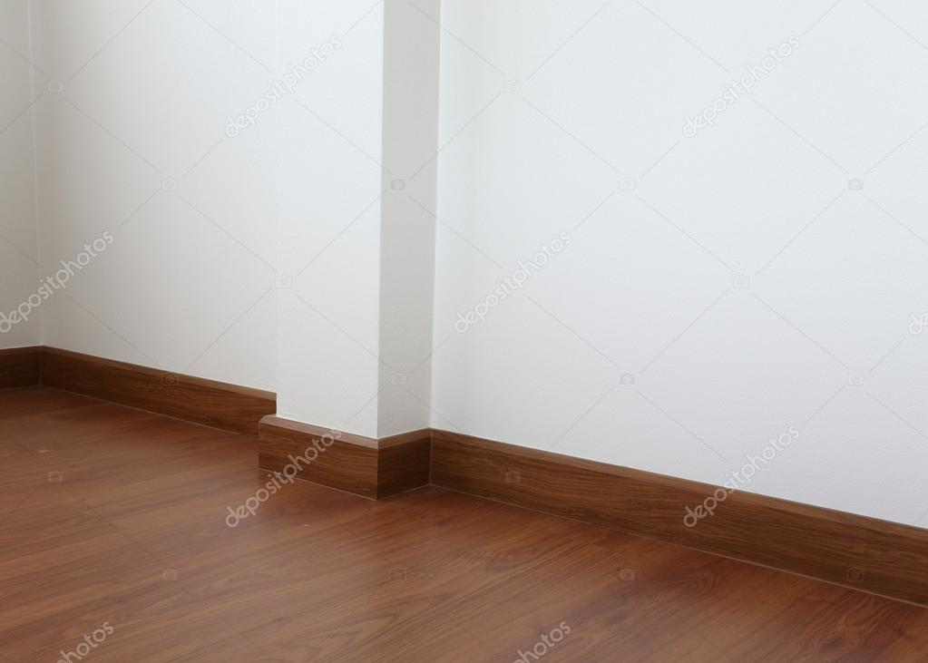 white mortar wall and wood floor in the room
