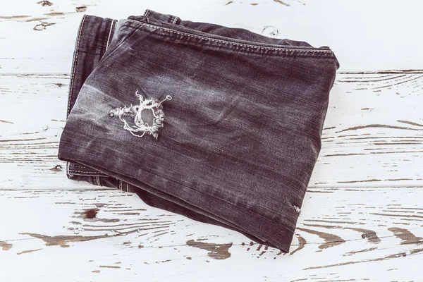 Black jeans on white wood, retro tone image — Stock Photo, Image