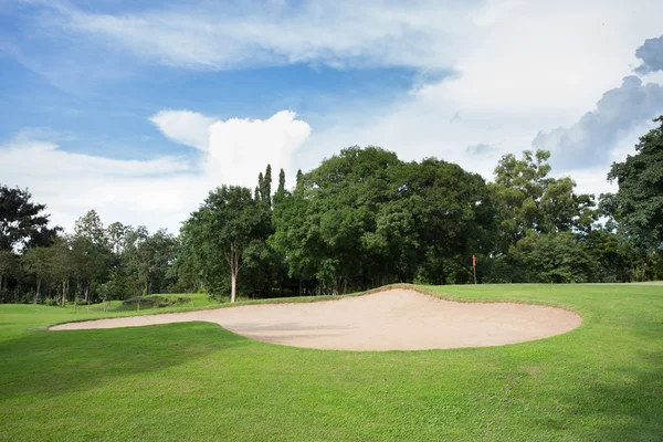 Golfbaan met zand bunker en groen gras — Stockfoto