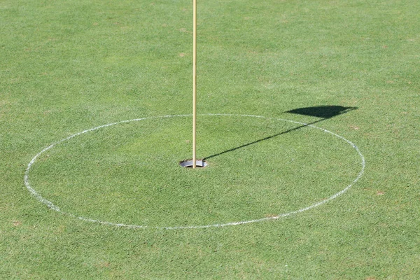 Golf hole op groen gras met schaduw vlag — Stockfoto