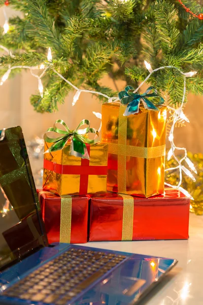 Laptop med presentförpackning och jul ljus bakgrund — Stockfoto