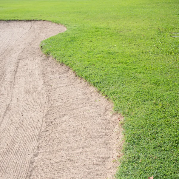 Песчаный бункер и зеленая трава поля для гольфа — стоковое фото