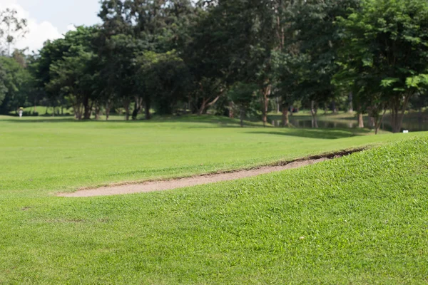 Golfbaan met zand bunker en groen gras — Stockfoto