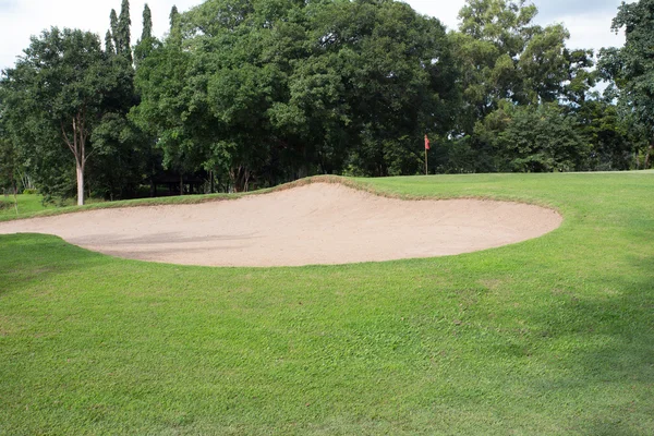 Golfbaan met zand bunker en groen gras — Stockfoto
