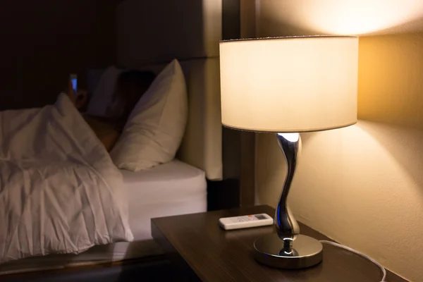 Woman using a smart phone in the bed — Stock Photo, Image