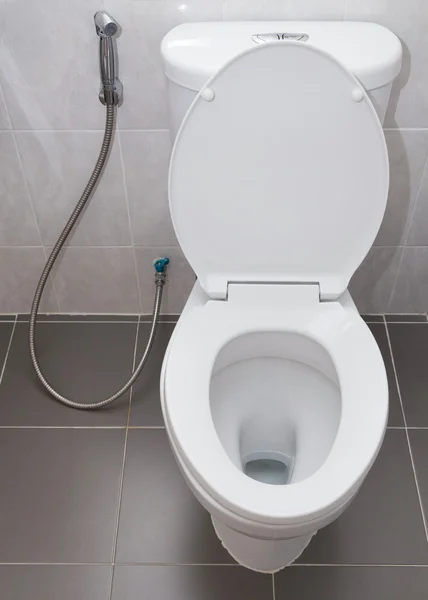 Туалет с белым смывом в современной ванной — стоковое фото