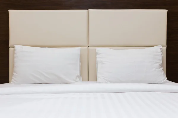 Спальня с белой подушкой и кожаным изголовьем — стоковое фото